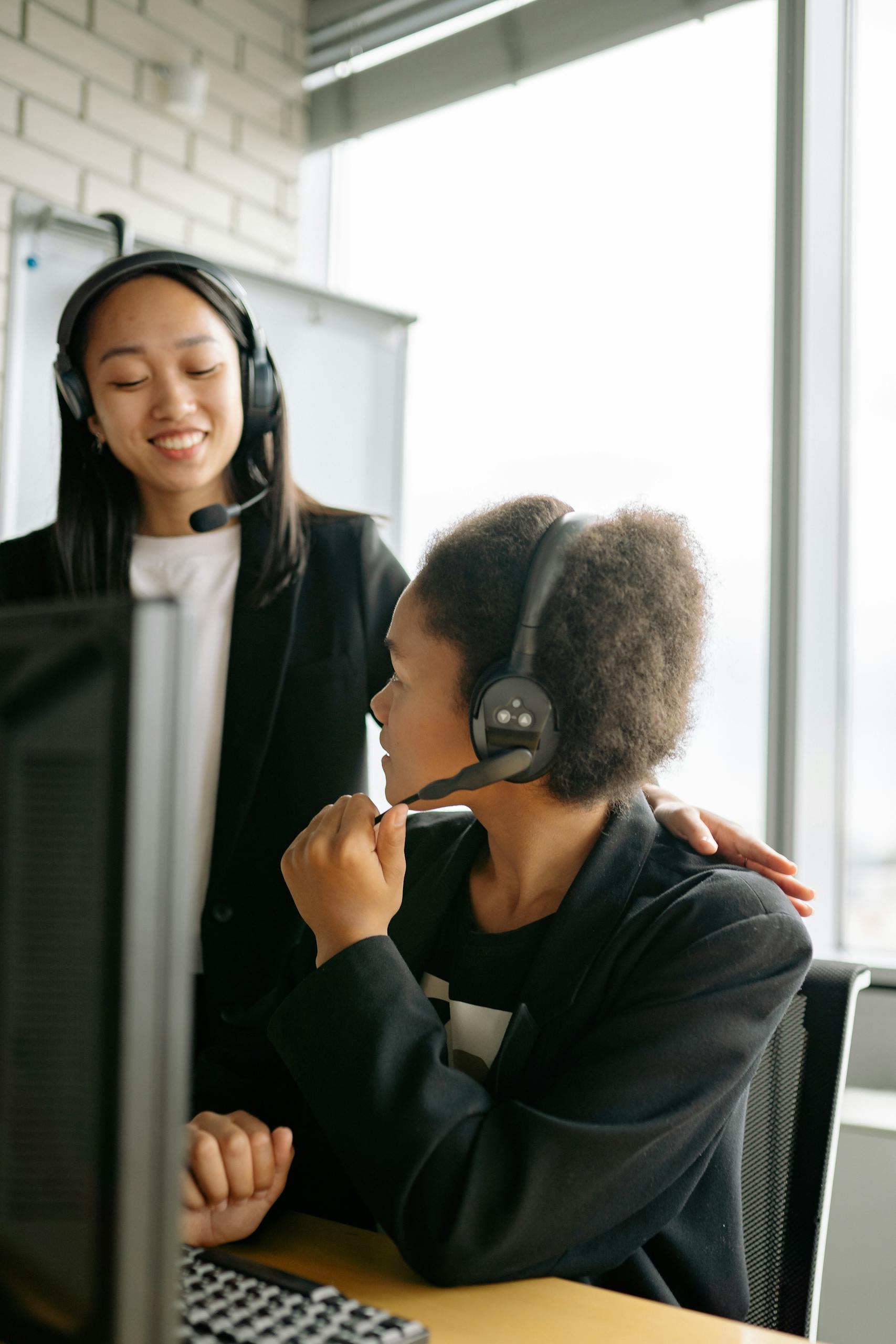 Two call center agents communicating in an office setting, enhancing teamwork.